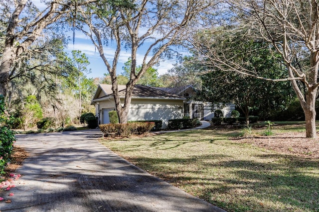 view of front of property with driveway, a front lawn, and an attached garage