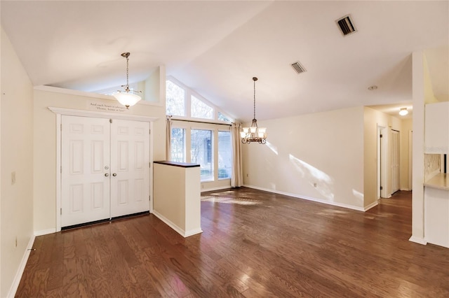 entrance foyer featuring dark wood-type flooring, vaulted ceiling, and an inviting chandelier