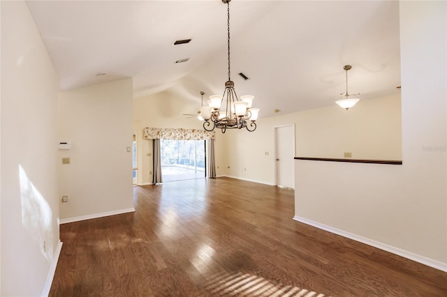 spare room with dark hardwood / wood-style floors, lofted ceiling, and a notable chandelier