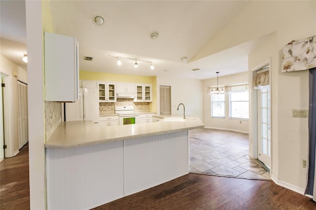 kitchen featuring kitchen peninsula, white appliances, sink, white cabinets, and lofted ceiling