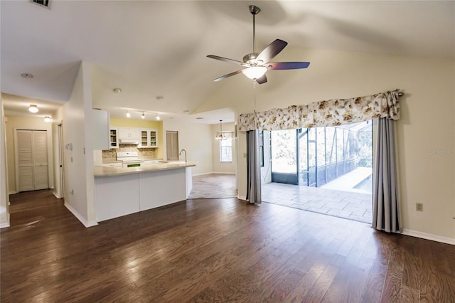 unfurnished living room featuring ceiling fan, sink, dark wood-type flooring, and vaulted ceiling