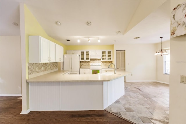 kitchen featuring white cabinets, white refrigerator, kitchen peninsula, and range