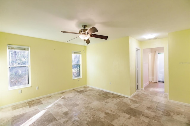 spare room featuring ceiling fan and plenty of natural light