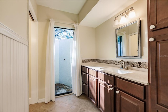 bathroom featuring tasteful backsplash, tile patterned floors, and vanity