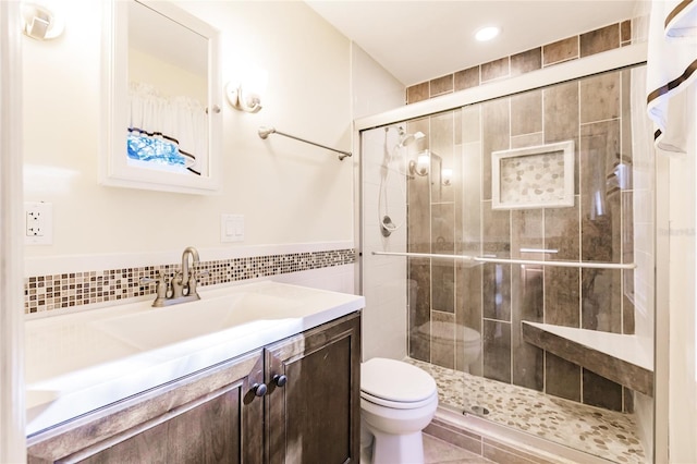 bathroom with walk in shower, vanity, toilet, and tile walls