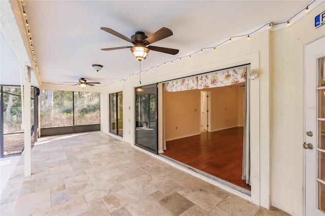 unfurnished sunroom with ceiling fan