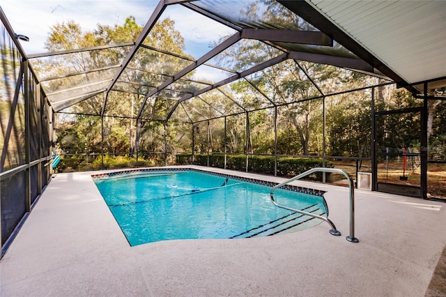 view of pool with glass enclosure and a patio