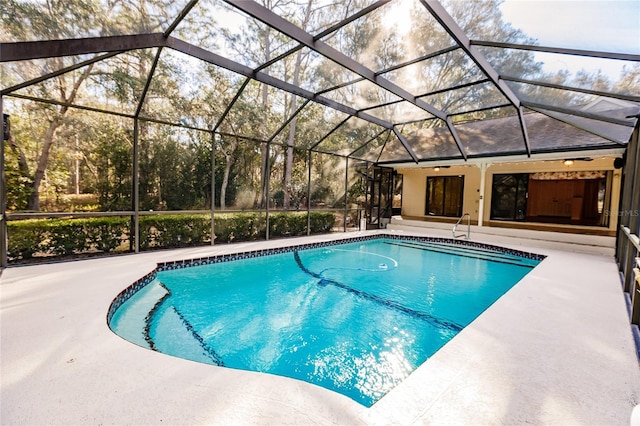 view of swimming pool featuring ceiling fan, a patio area, and a lanai