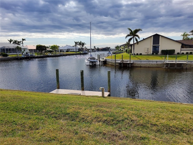 dock area featuring a lawn and a water view