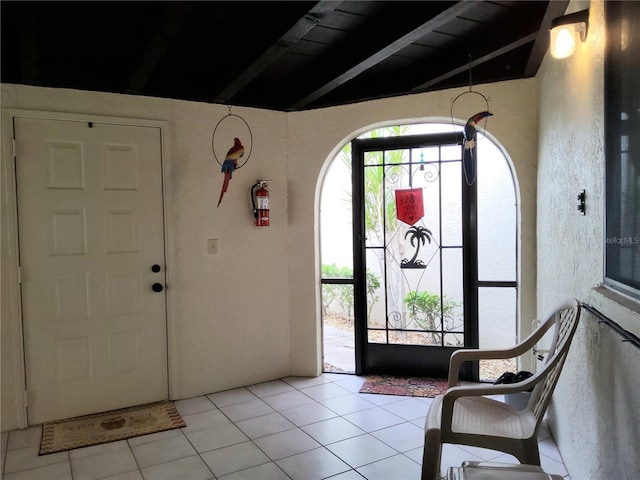 tiled foyer with wood ceiling and beamed ceiling