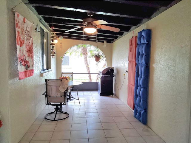 interior space with ceiling fan and beamed ceiling