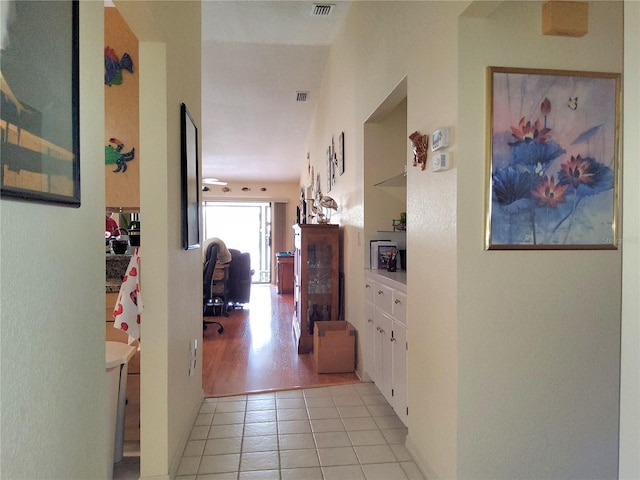 hallway featuring light tile patterned floors and built in features