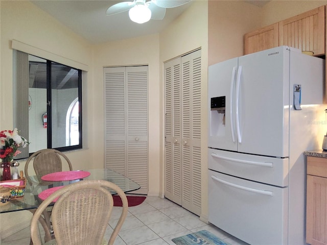 kitchen featuring ceiling fan, light tile patterned floors, white fridge with ice dispenser, and light brown cabinets