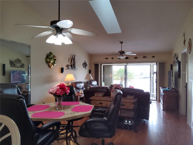 dining room featuring hardwood / wood-style flooring, lofted ceiling with skylight, and ceiling fan