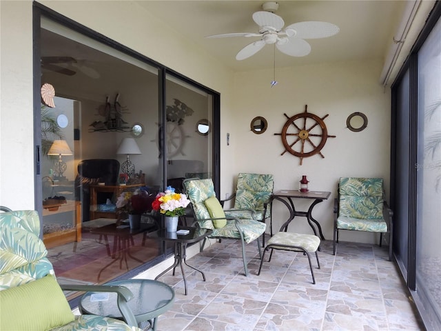 sunroom / solarium featuring ceiling fan