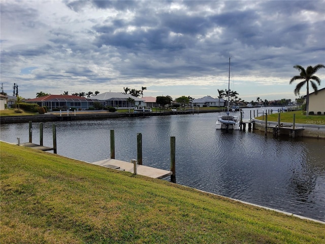 view of dock with a water view and a yard