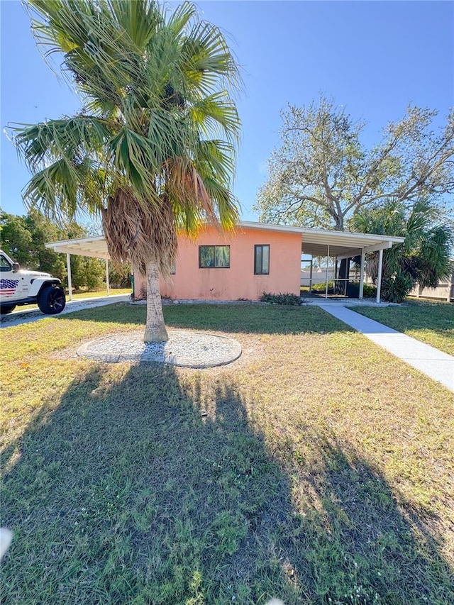 view of front of home with a front lawn and a carport