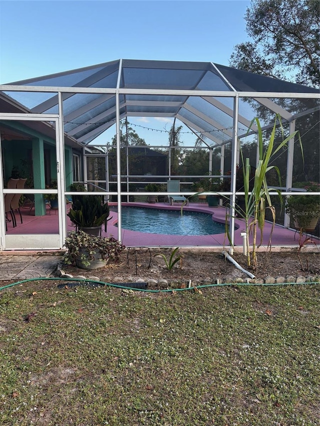 view of pool featuring glass enclosure and a patio area