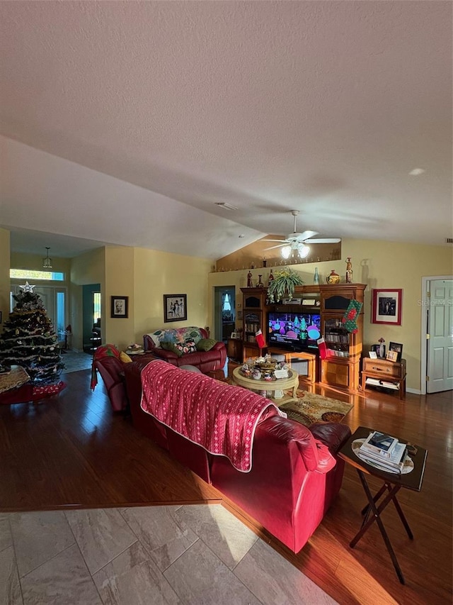 living room with a textured ceiling, ceiling fan, lofted ceiling, and hardwood / wood-style flooring