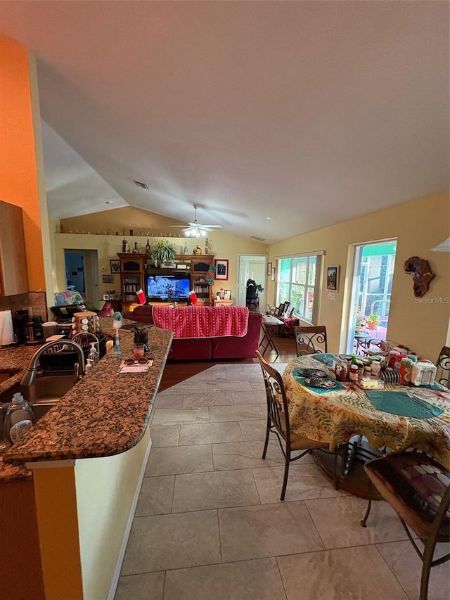 dining room with ceiling fan, lofted ceiling, and sink