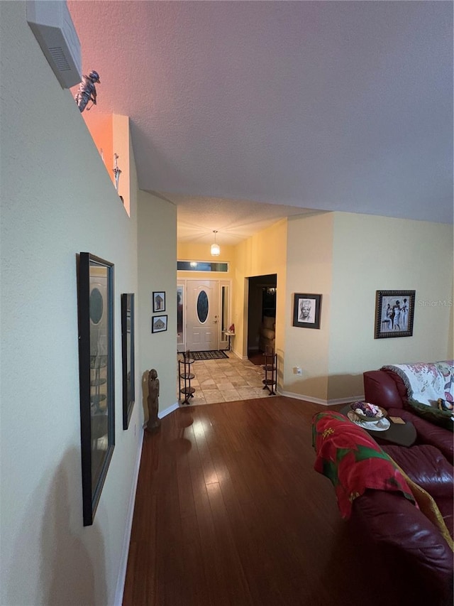 hall with light hardwood / wood-style floors and a textured ceiling