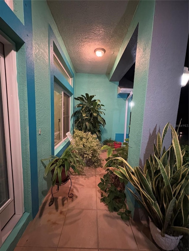 hallway featuring a textured ceiling and tile patterned floors