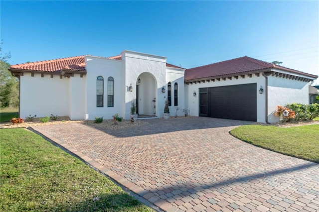 mediterranean / spanish-style house with a front lawn and a garage