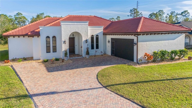 mediterranean / spanish house with a front lawn and a garage