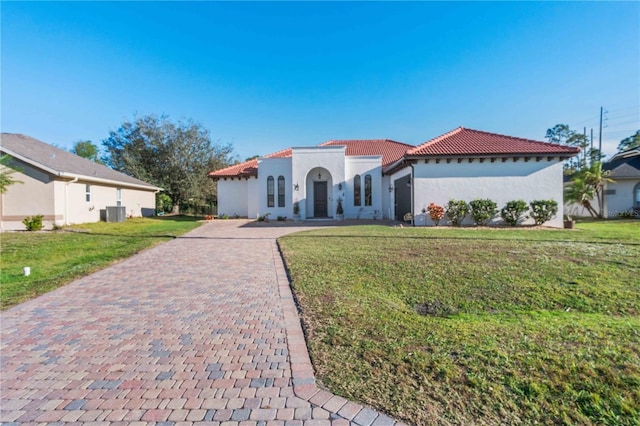 mediterranean / spanish home featuring central AC unit and a front lawn