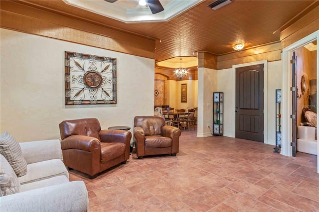 living room featuring ceiling fan with notable chandelier and ornamental molding