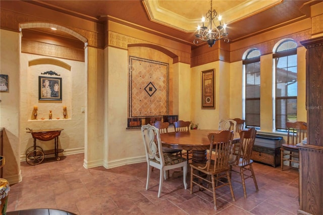 dining room featuring a raised ceiling, crown molding, and an inviting chandelier