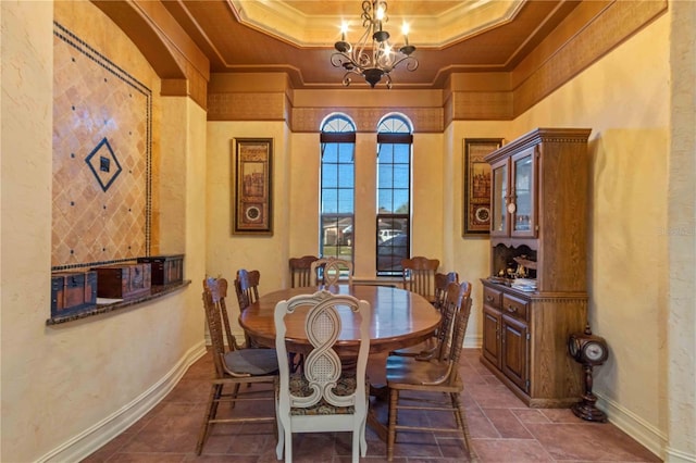 dining area featuring a tray ceiling, crown molding, a towering ceiling, and an inviting chandelier