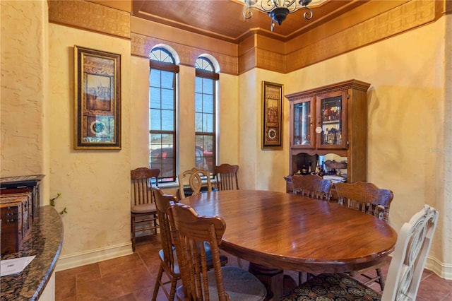 dining space featuring crown molding and a chandelier