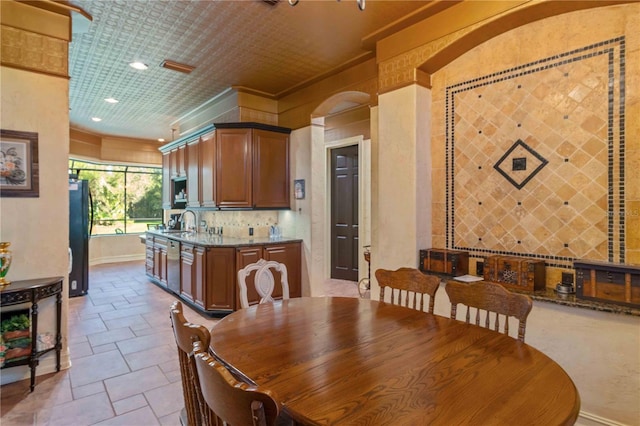 dining space with crown molding and sink