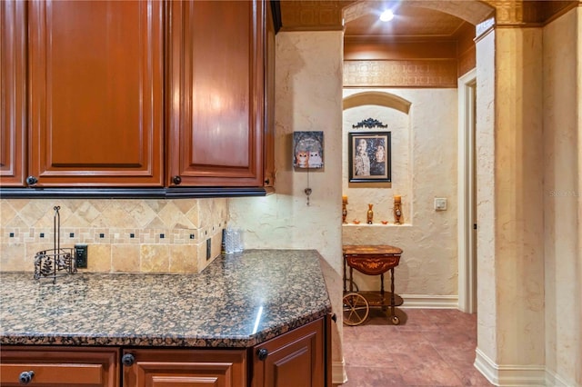 kitchen featuring backsplash and dark stone countertops