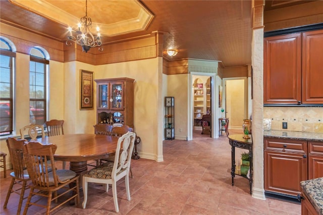 dining room featuring ornamental molding, a tray ceiling, and an inviting chandelier