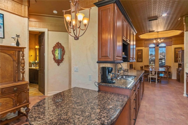 kitchen featuring dark stone countertops, crown molding, sink, and pendant lighting