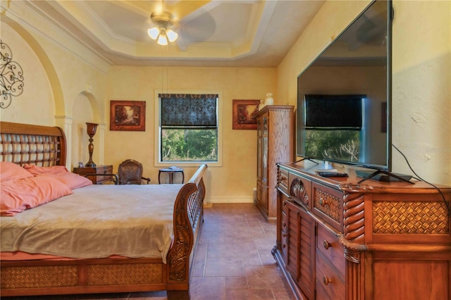 bedroom with a tray ceiling, ceiling fan, and ornamental molding