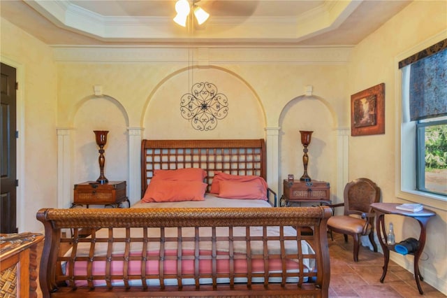 bedroom featuring a raised ceiling, ceiling fan, and ornamental molding