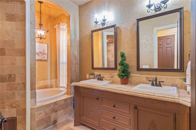 bathroom featuring vanity, tiled bath, and an inviting chandelier