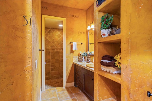 bathroom featuring vanity and tiled shower