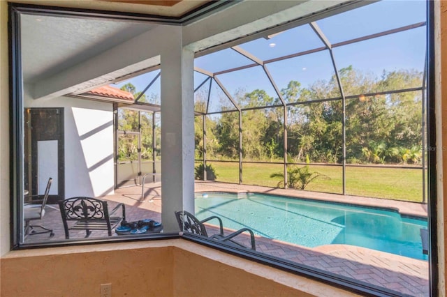 view of swimming pool featuring a patio and a lanai