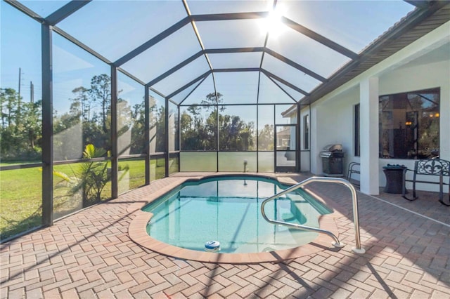 view of pool featuring glass enclosure and a patio area