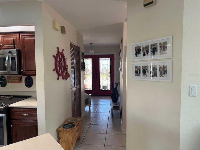 corridor with french doors and light tile patterned flooring