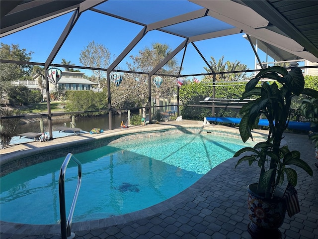 view of pool with a patio, a water view, and glass enclosure