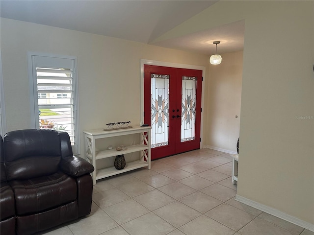 foyer entrance with vaulted ceiling, light tile patterned floors, and french doors