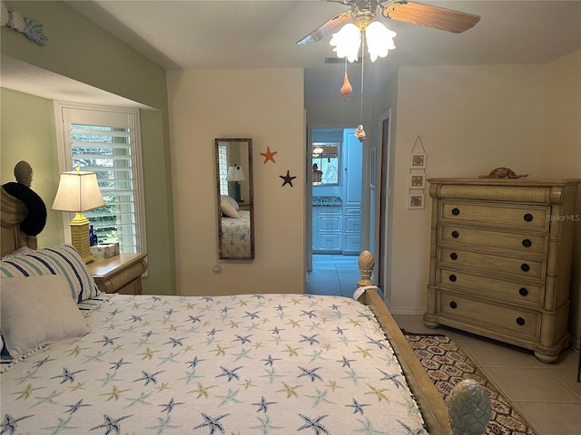 bedroom featuring tile patterned floors, ceiling fan, and ensuite bath