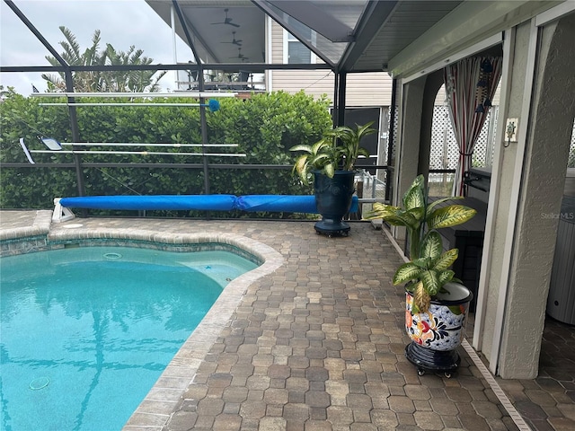 view of swimming pool featuring a patio and glass enclosure