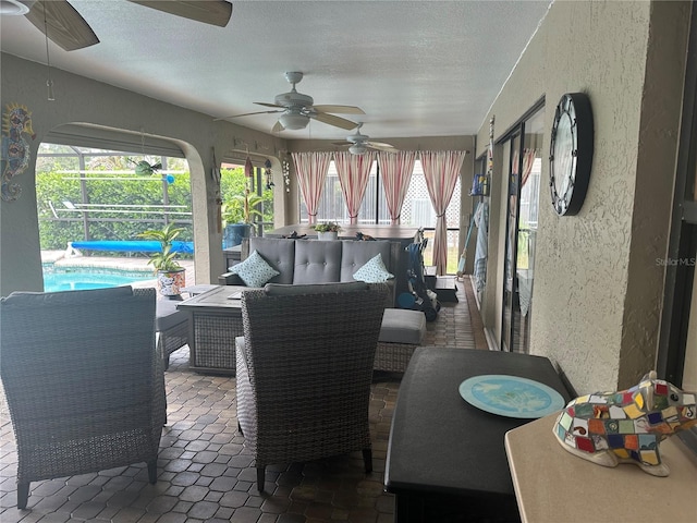 sunroom / solarium featuring ceiling fan