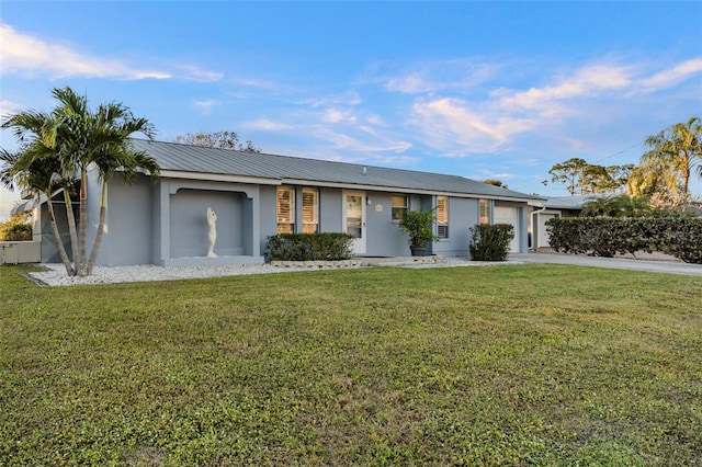 ranch-style house featuring a garage and a front lawn